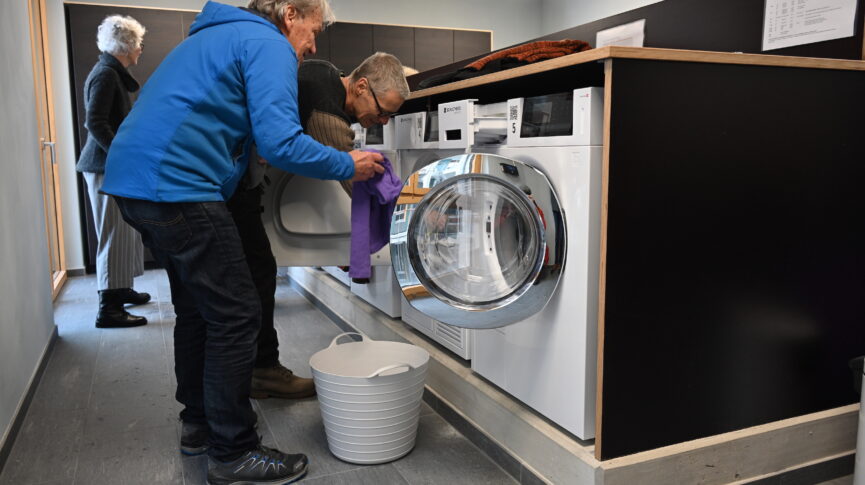 Zwei Männer beim Reinigen der Waschmaschine