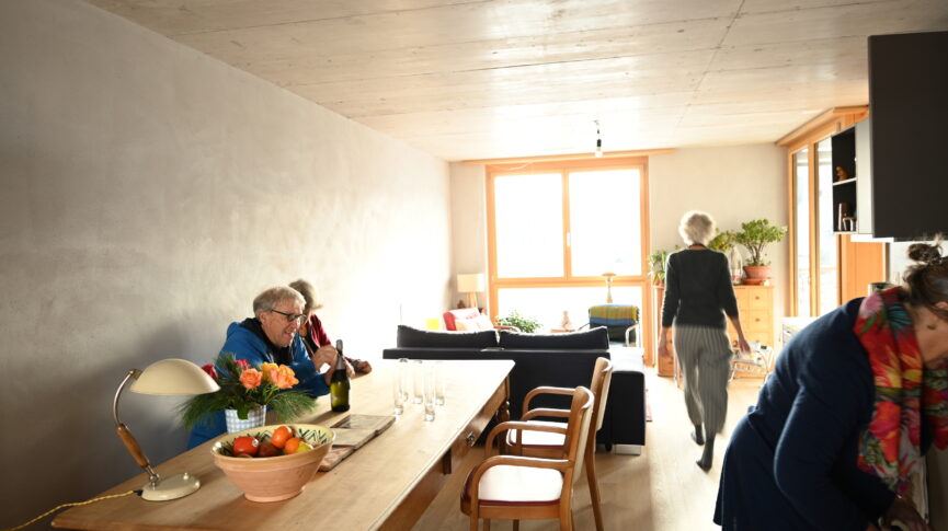 4 Personen in einer Wohnung mit Tisch und Sofa