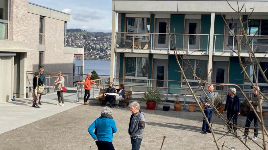 Gruppen von Bewohner:inen auf grossem Platz vor dem Bistro
