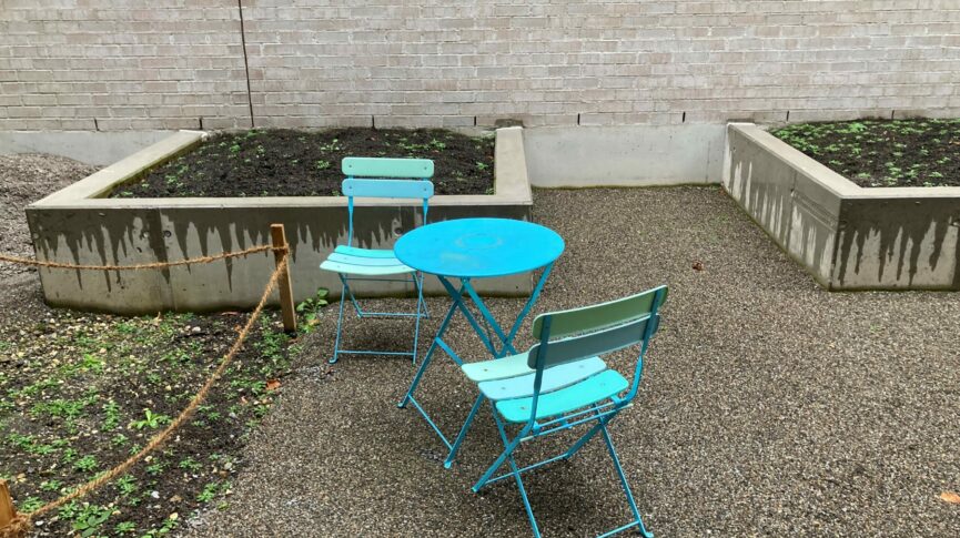 Gartentisch mit zwei Stühlen auf Kiesplatz im Erdgeschoss