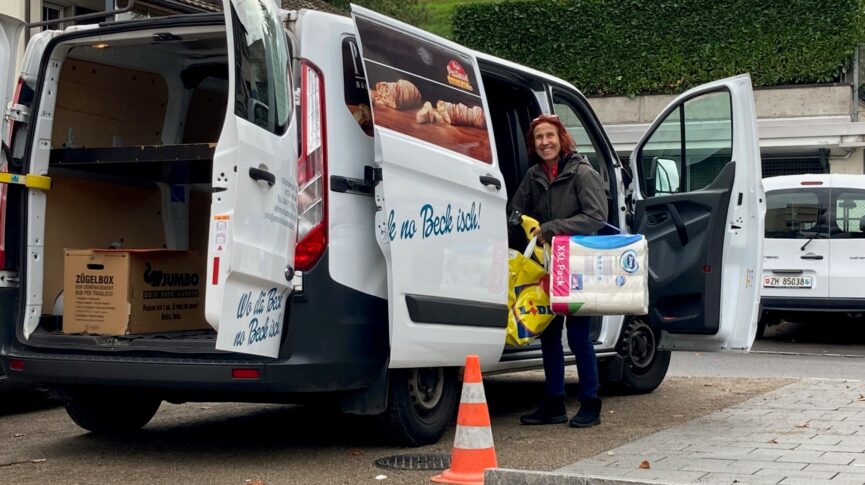 Eine Bewohnerin mit Plastiktaschen und WC-Papier vor Zügeltransporter