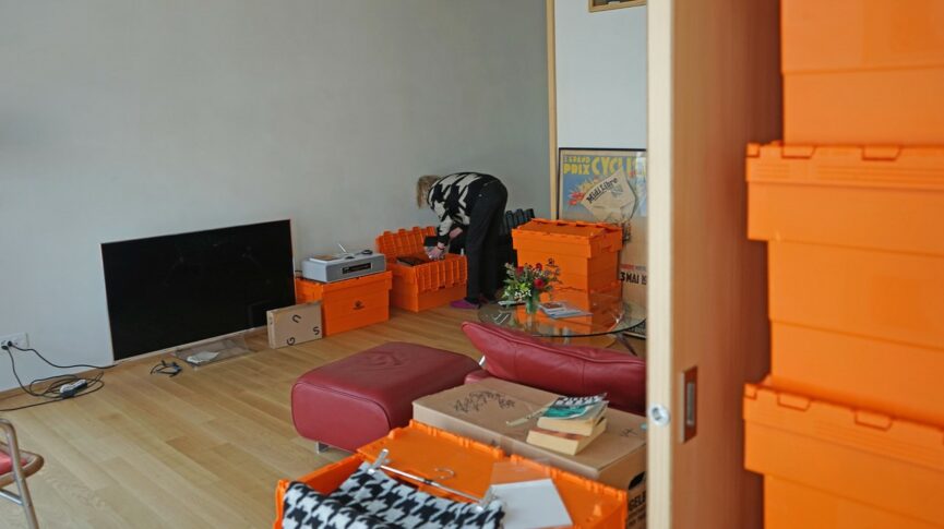 Wohnung mit Bewohnerin und farbigen Zügelkisten.